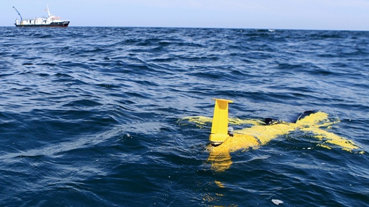An underwater glider prior to descent. In the background the research ship Ludwig Prandtl. -image: HZG-